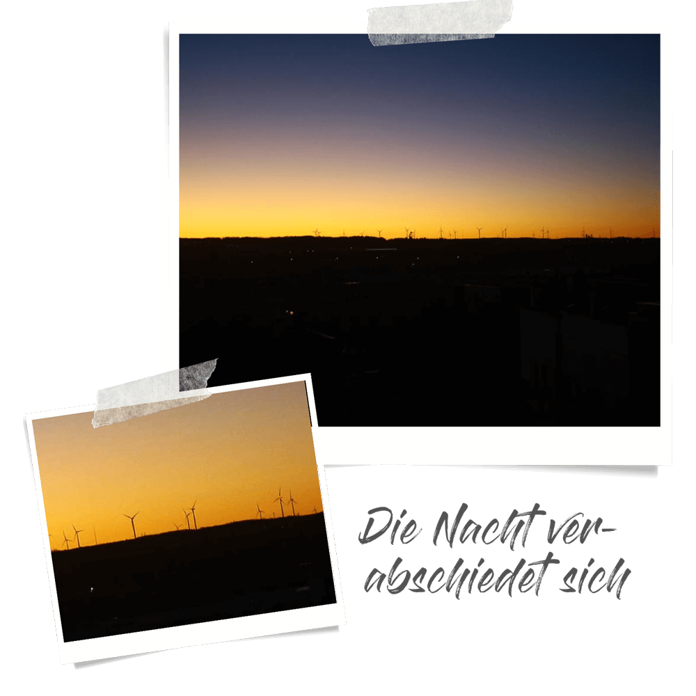 Sonnenaufgang über Berg, am Horizont sind Windräder zu sehen