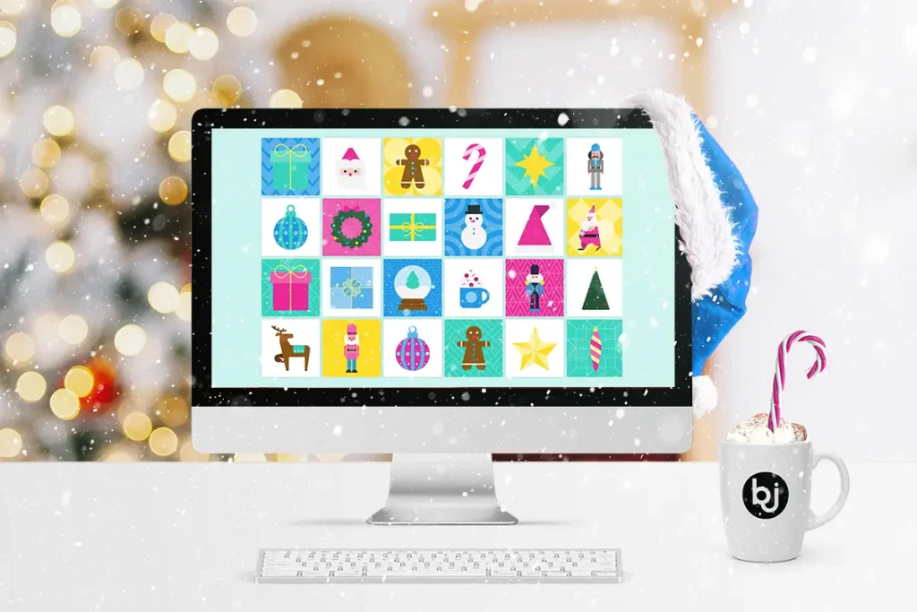 Ein Schreibtisch mit Computerscreen in weihnachtlichem Setting, auf den es schneit als Symbolbild für den Schneeflocken-Effekt.