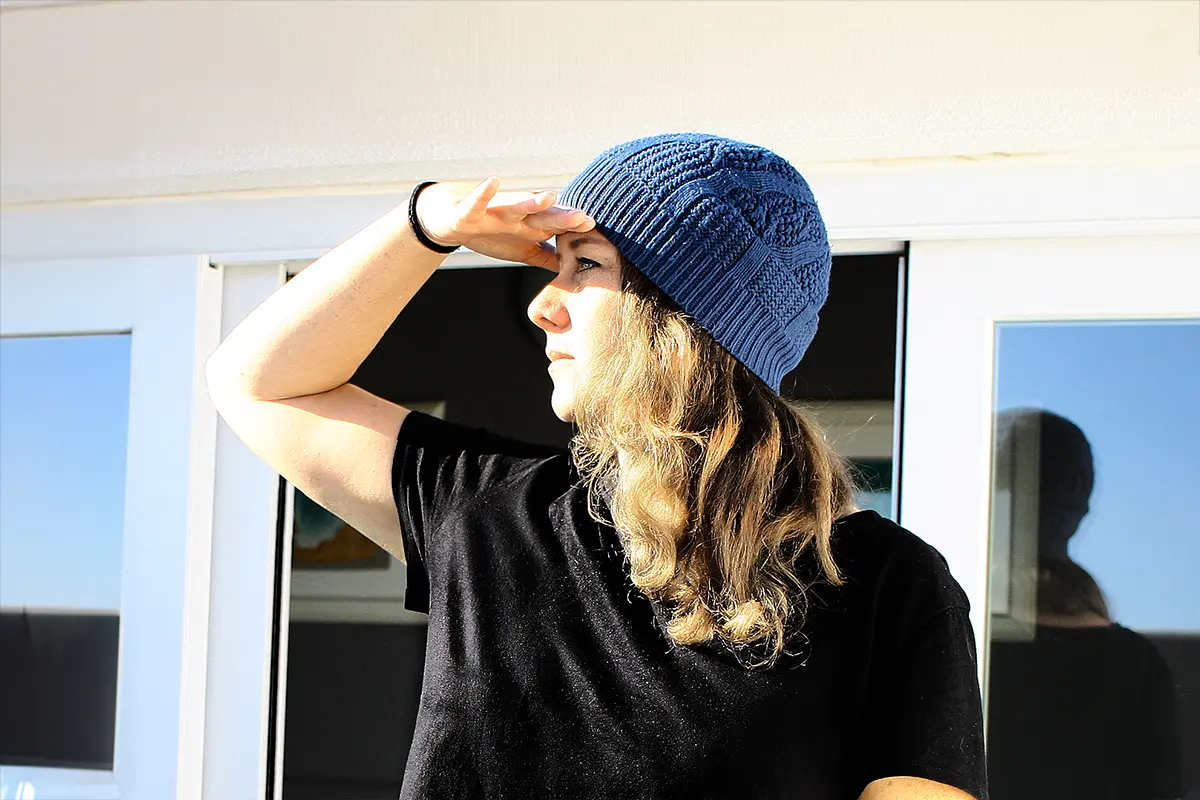 Britta steht im Profil in der Sonne und schaut in die Ferne, während sie über vorschnelle Annahmen, Kritik und Kritikfähigkeit und die Frage, warum wir einander so selten Zeit lassen, nachdenkt.