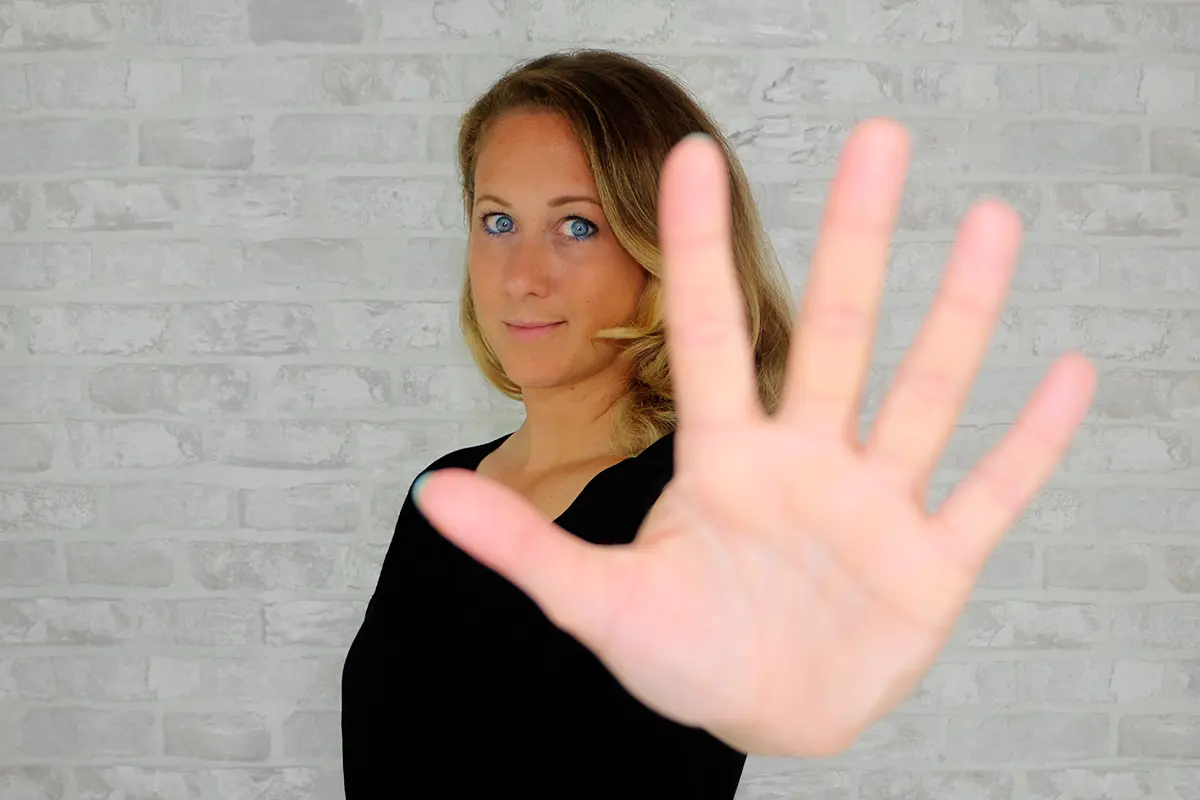 Britta hält ihre ausgestreckte Hand mit 5 Fingern in die Kamera als Symbol für die 5 häufigsten Anfängerfehler bei Deiner Business Website.