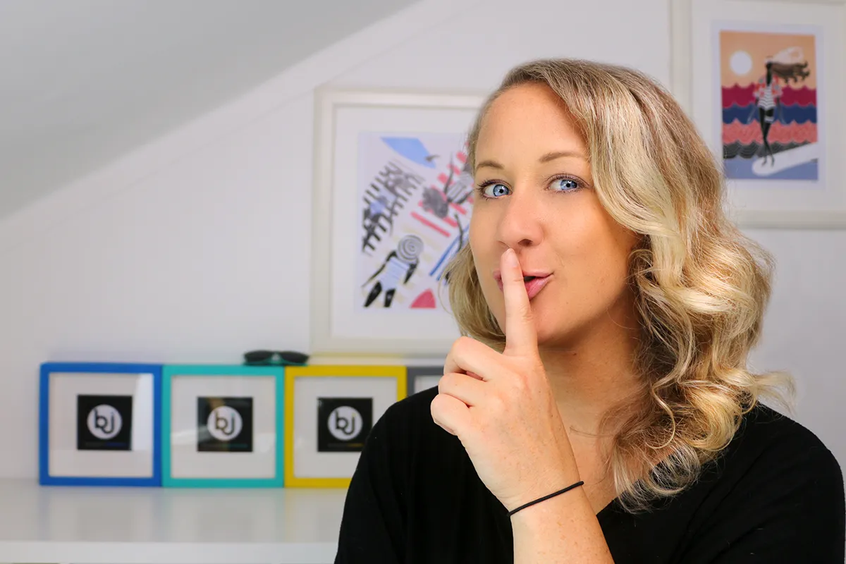 Britta hält einen Finger an ihren Mund und verrät Dir: Ich wollte Selbstständigen mal beibringen, ihre Website selbst zu bauen – warum ich das heute anders sehe.