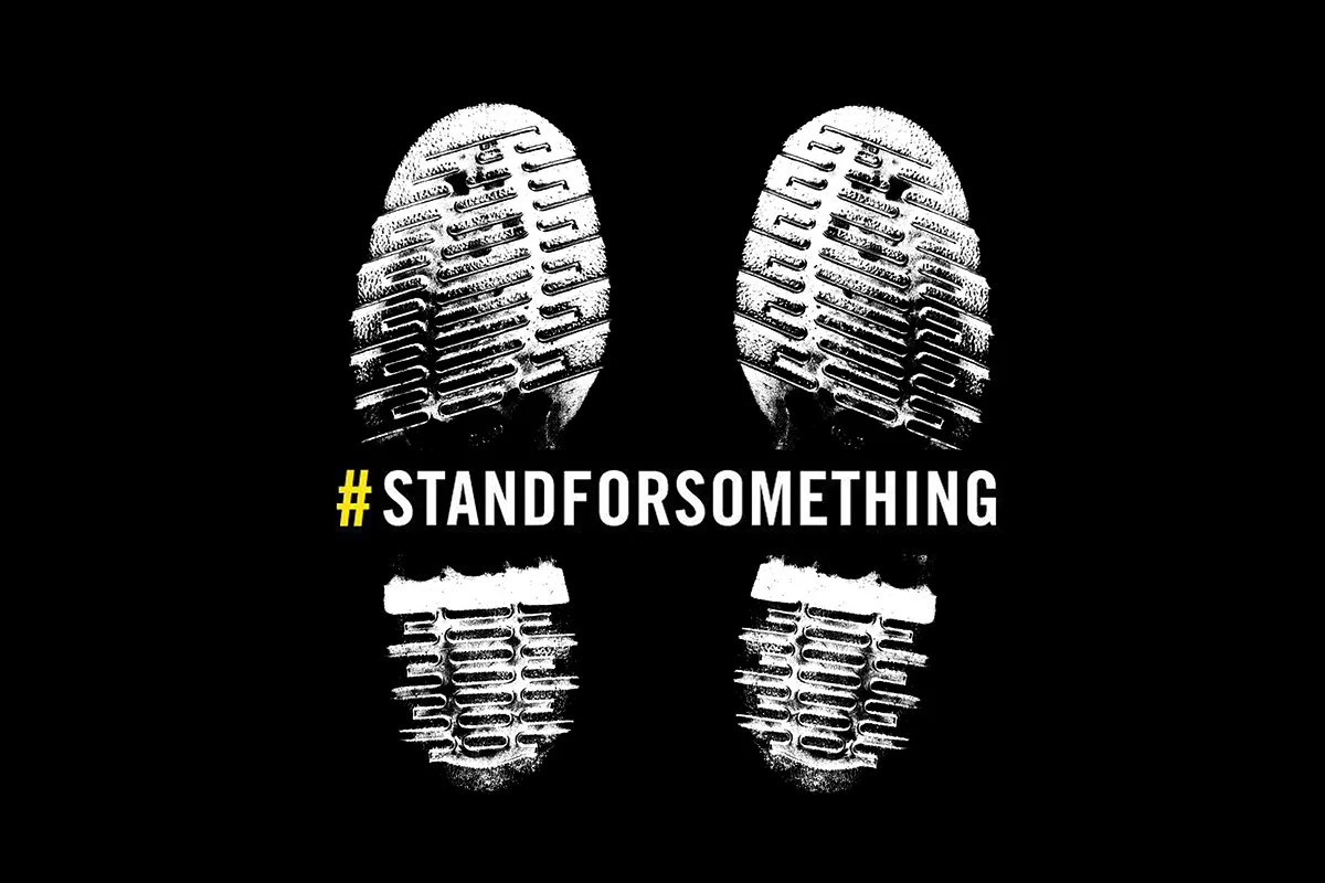 Zwei weiße Abdrücke von Schuhsohlen auf schwarzem Hintergrund, darüber der Claim Stand for Something von Dr. Martens als Symbol für meinen Doctober 2026.